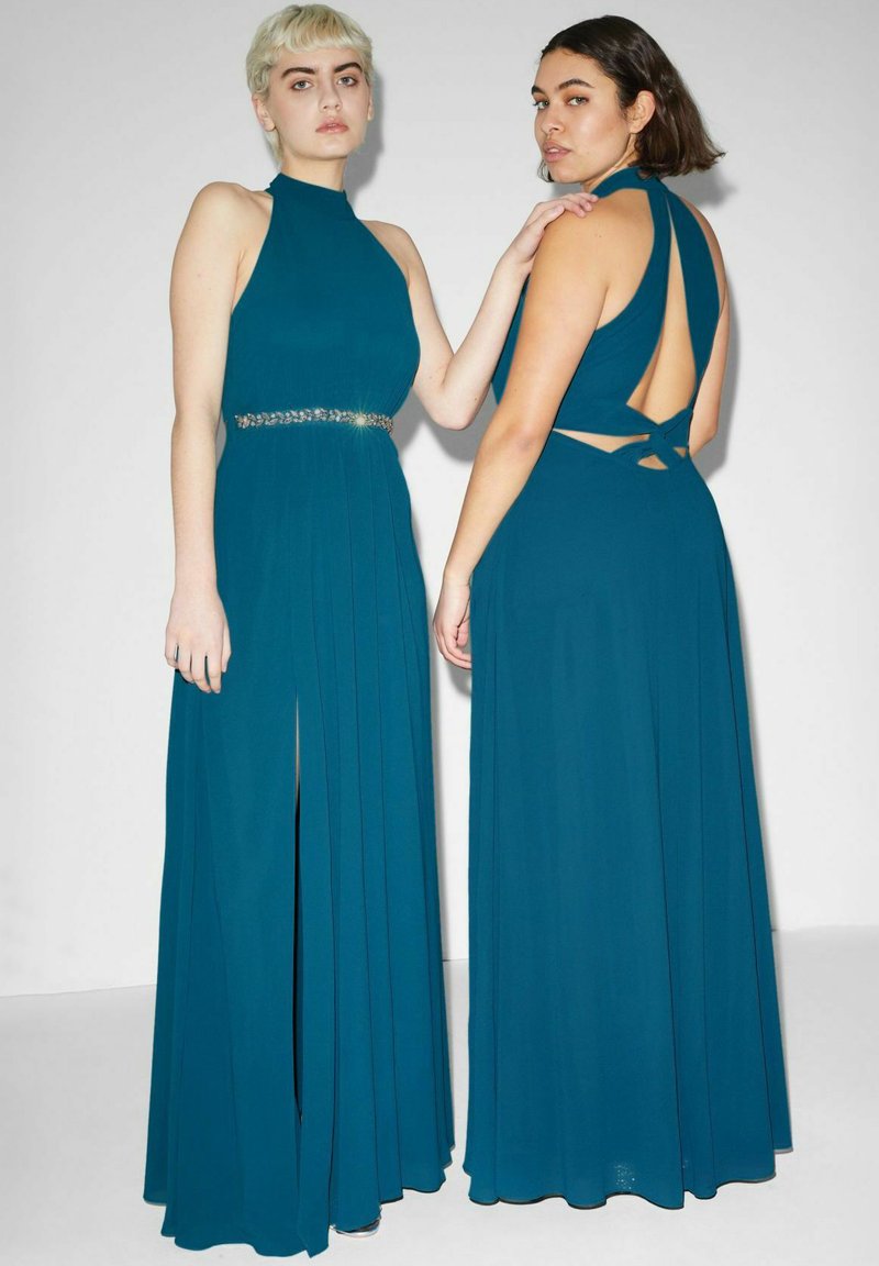 Abiti lunghi color teal con colletti alti, gonne plissettate e un cinturone gioiello. Il retro presenta un design con tagli e bretelle incrociate.
