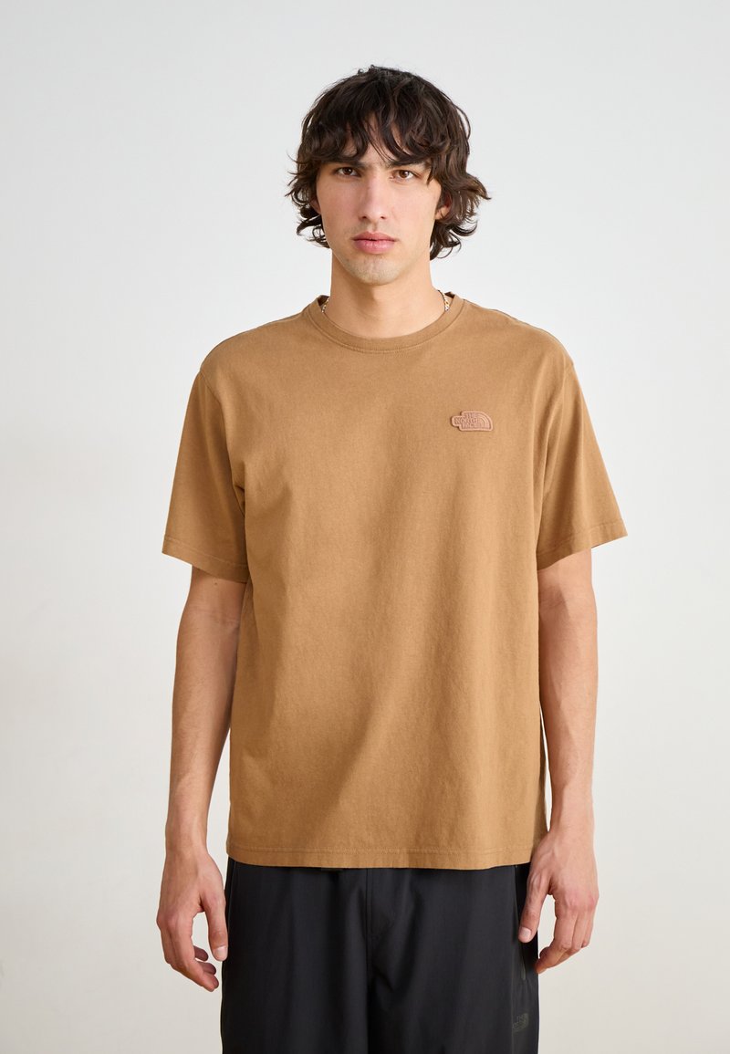 Braunes Baumwoll-T-Shirt mit kurzen Ärmeln und Rundhalsausschnitt, ausgestattet mit einem kleinen gestickten Logo auf der linken Brust. Lässige Passform und glatte Textur.