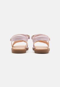 Rosa sandaler med åpen bakdesign og justerbare stropper, med en glatt tekstur og robuste brune såler.
