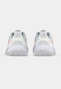 Λευκά και γκρι αθλητικά παπούτσια με ροζ λεπτομέρειες, επάνω μέρος από διχτυωτό ύφασμα, επένδυση στον αστράγαλο, υφή στη σόλα από καουτσούκ και χαρακτηριστικό λογότυπο με τρεις ρίγες.