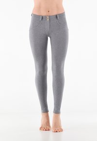 Leggings grigi in tessuto morbido, con un design aderente, vita con due bottoni e tasche frontali discrete.