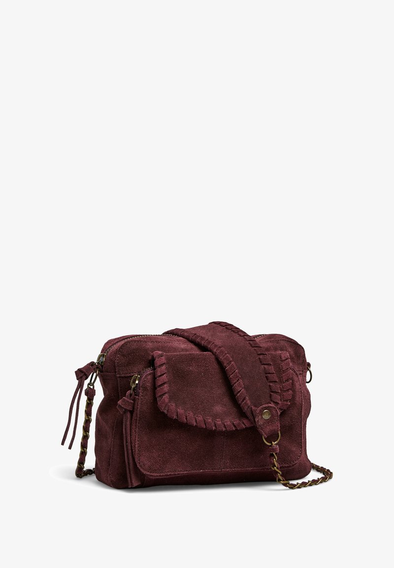 Sac à main en daim bordeaux avec une bandoulière tressée, fermeture éclair et poche à rabat dotée d'un design cousu et d'accents à franges.