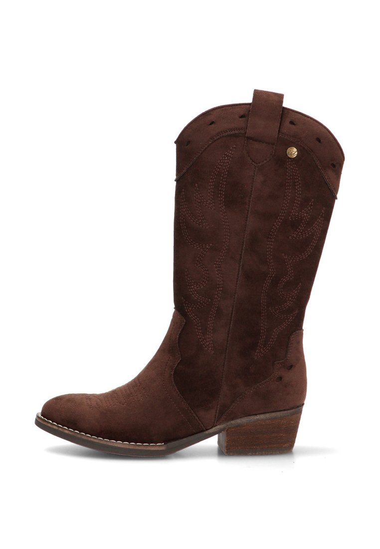Bota vaquera de ante marrón con costuras decorativas, tacón medio apilado y lengüeta en la parte superior del caño.