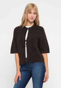 Brun kortärmad cardigan gjord av mjukt material, med rund halsringning och knytning framtill. Slät textur utan tydliga mönster.