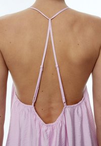 Rosa ärmelloses Kleid mit tiefem Rückendetail, dünnen Trägern und gerafftem Stoff um die Taille für eine entspannte Silhouette.