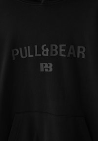 Sweat à capuche noir avec texte "PULL&BEAR" texturé et un logo stylisé "PB" en dessous sur la poitrine, doté d'une poche kangourou à l'avant.