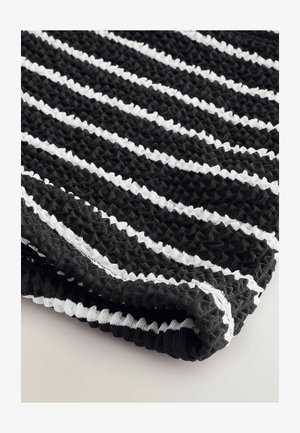 Tissu rayé noir et blanc avec un design texturé et tissé ; présente un aspect smocké et un bord replié mettant en valeur le contraste.