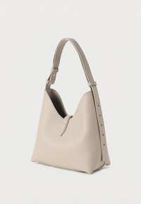 Μπεζ δερμάτινη τσάντα ώμου με δομημένο σχεδιασμό, που διαθέτει φαρδιά ράβδο με ρυθμιζόμενο μήκος και διακριτικό χρυσό λογότυπο στη βάση.