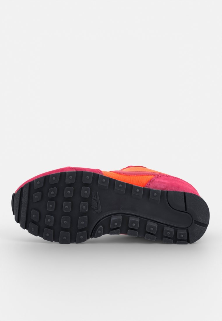 Zapatillas deportivas con un upper multicolor en rosa y naranja, que cuentan con una suela de goma negra texturizada con agarres de tracción.