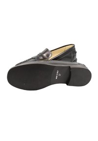 Mocassini neri in pelle con finitura liscia, caratterizzati da una striscia decorativa e suola texturizzata, progettati per il comfort e la facilità di calzata.