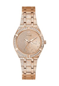 Roza zlata Guess ročna ura s kristali obroča, številčnico in kovinskim verižnim pasom, ki ima tri kazalce in brez števila oznak.
