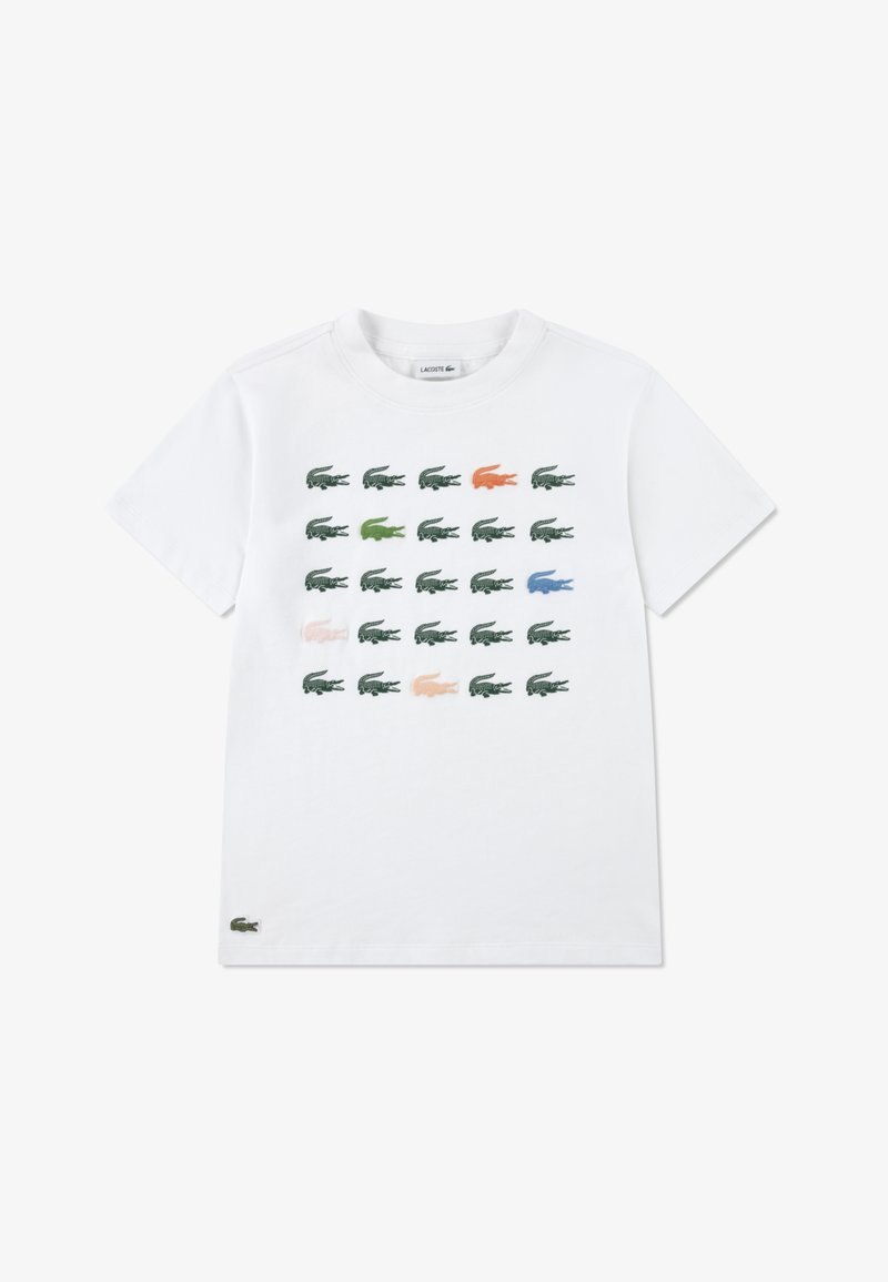 Λευκό βαμβακερό t-shirt με στρογγυλή λαιμόκοψη, διακοσμημένο με ένα πλέγμα μικρών χρωματιστών λογότυπων κροκοδείλων σε πράσινο, μπλε, πορτοκαλί και ροζ.