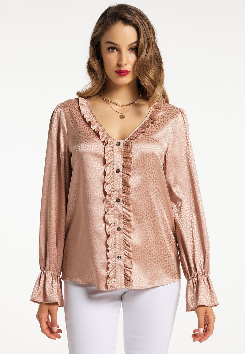 Camicia rosa chiaro con ruffles in tessuto lucido e motivo testurizzato. Presenta un collo a V, chiusura con bottoni frontale e maniche a campana.