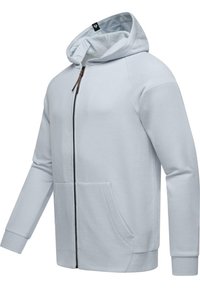 Sudadera con cremallera en gris claro, confeccionada en una tela suave, que presenta una capucha amplia, mangas largas y dos bolsillos frontales. Detalles en cremallera oscura.