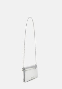 Stříbrná metalická kabelka přes rameno s elegantním, obdélníkovým tvarem, hladkým povrchem a řetízkem na popruhu. Má klopu a decentní branding.