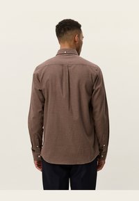 Bruin geruit overhemd met lange mouwen, een button-down kraag, twee knoopmanchetten en een rugplooi voor extra bewegingsvrijheid, gemaakt van geweven stof.