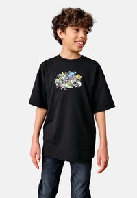 Black cotton t-shirt featuring a colorful graphic print of various cartoon animals on the front; relaxed fit with short sleeves.