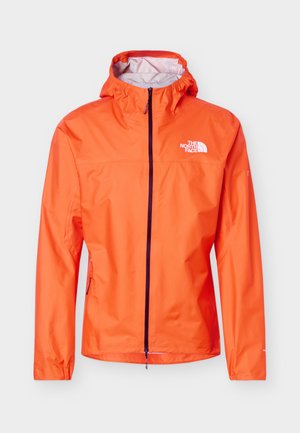 Chaqueta ligera naranja con capucha, cremallera frontal negra y logo blanco de "The North Face" en el pecho y la manga, diseñada para uso en exteriores.