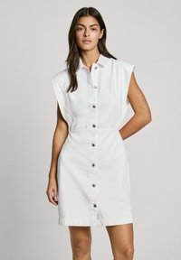 Witte shirtjurk met korte mouwen, knopen aan de voorkant en een elastische taille. Gemaakt van katoen; heeft zwarte knopen en een minimalistisch ontwerp.
