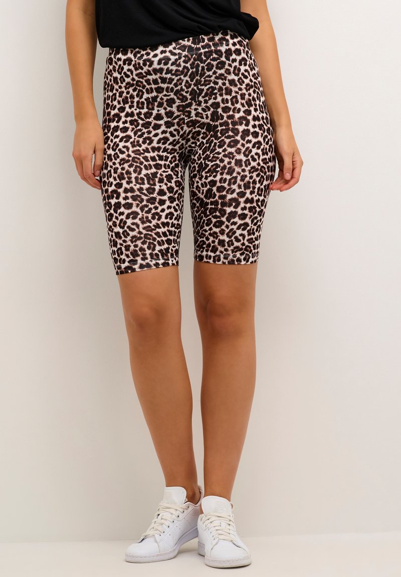 Leopardenmuster-Shorts mit figurnahem Schnitt, aus einem elastischen Material, mit hoher Taille und sportlichem Stil. Weiße Sneakers runden das Outfit ab.