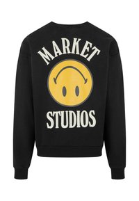 Fekete pulóver, amelyen egy nagy sárga mosolygós arc és fehér felirattal a "MARKET STUDIOS" felirat található a hátoldalon. Pamut anyagú, kerek nyakú dizájn.