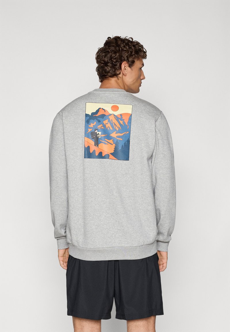 Grijze sweatshirt met geribbelde manchetten en zoom, voorzien van een kleurrijke berglandschap print op de achterkant in oranje, blauw en gele tinten.