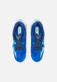 Un paio di scarpe da atletica blue con dettagli bianchi e turchesi, lacci blu scuro e un logo sulla linguetta e sulla soletta, viste dall'alto.