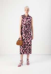 Ροζ φόρεμα midi με λεοπάρ σχέδιο, κουμπωτό μπροστά και ζώνη στη μέση. Συνδυασμένο με στραπένια μωβ τακούνια και μια μικρή υφασμάτινη καφέ τσάντα.