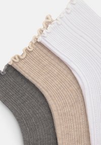 Three pairs of ribbed socks in dark gray, beige, and white, with a gathered edge design, showcasing a soft texture and varied colors.