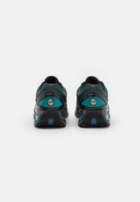 Black running shoes with a textured upper, highlighted by teal accents and a visible air bubble feature on the heel. Red and blue outsole details.