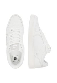 Par de zapatillas blancas de corte bajo, una mostrando la vista superior con los cordones, y la otra en vista lateral destacando los detalles de la suela y la costura.