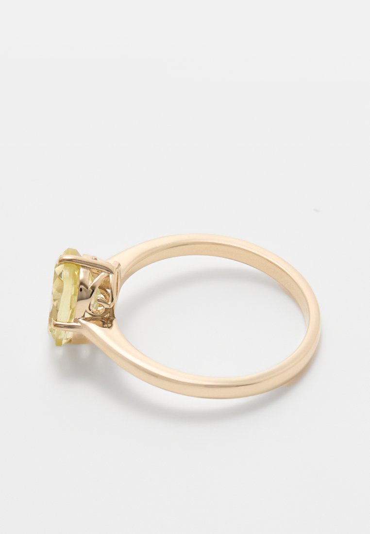 Goldfarbener Ring mit einem facettierten, hellgelben Stein in einer Krappenfassung und einem glatten Band. Minimalistisches Design, ohne zusätzliche Verzierungen.
