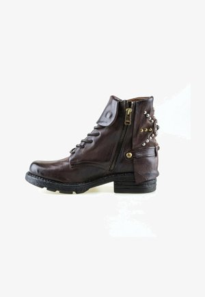 Bottine en cuir marron foncé avec fermeture éclair latérale, rabat décoratif et clous métalliques autour du talon sur fond blanc.
