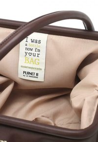 Interno in tessuto beige di una borsa marrone con un'etichetta che indica che è realizzata con bottiglie di plastica riciclate da Planet B, Le Pandorine.
