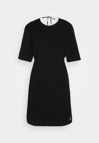 Μαύρο φόρεμα κοντό μανίκι με στρογγυλή λαιμόκοψη, στενή μέση και υφασμάτινη υφή. Διαθέτει κλείσιμο με φιόγκο στην πλάτη και λεπτομέρεια λογότυπου στο στρίφωμα.