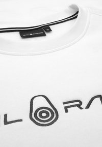 Sudadera blanca con cuello redondo y logo negro bordado con un gráfico ovalado y texto horizontal. La etiqueta dice "Sail Racing," tamaño M.