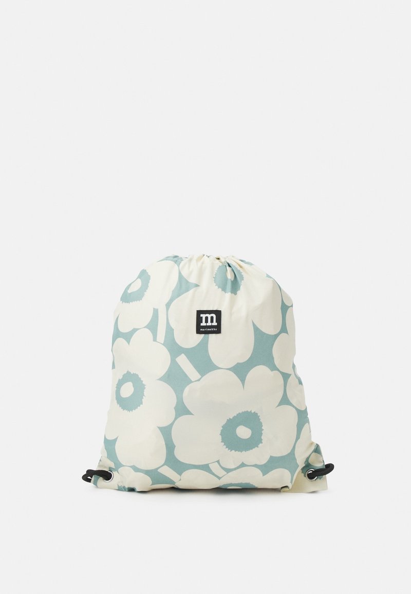 Sac à dos à cordon avec de grandes fleurs crème sur un fond bleu clair et une étiquette noire avec un logo blanc "m" au centre.