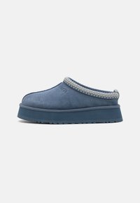 Dark blue suede slip-on shoe with a textured woven accent around the collar and a thick rubber sole, designed for comfort and ease of wear.