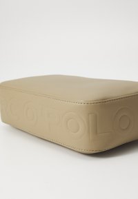 Borsa in pelle beige con logo impresso. Forma rettangolare, superficie liscia e dettaglio di cucitura sottile lungo il bordo.