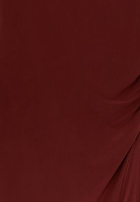 Tissu en velours rouge profond avec des plis doux et une texture lisse et riche.