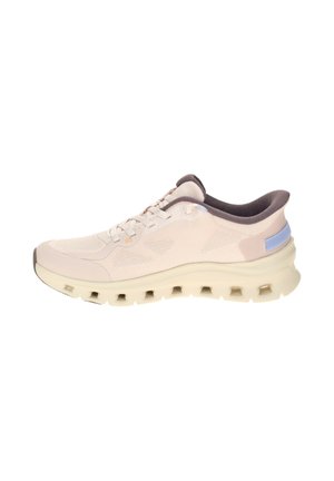 Zapatilla deportiva beige claro con parte superior de malla, lengüeta lavanda, suela acolchada con respiraderos rectangulares y forro interior gris oscuro.