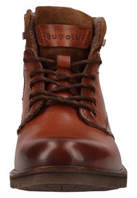 Bruine leren enkelboot met suede accenten, ronde neus, metalen ogen en bruine veters. Beschikt over een gevoerde kraag en rubberen zool.