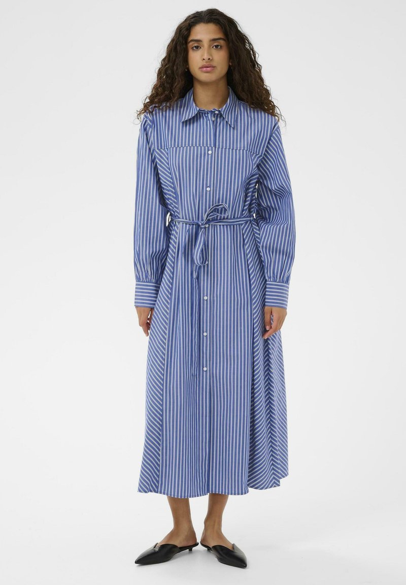 Robe-chemise à manches longues à rayures bleues et blanches, avec un col à revers, une fermeture à boutons sur le devant et une ceinture ajustable à la taille, offrant une coupe décontractée.