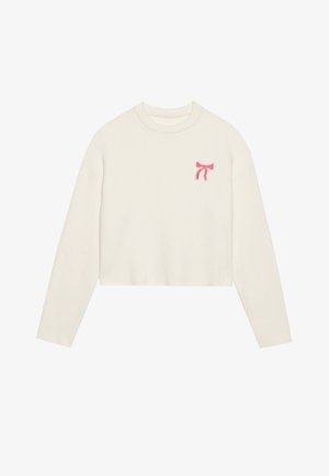 Geknipte, langelijf trui van zacht, textuurvol crèmekleurig materiaal. Kenmerkt een roze geborduurd strikdetail op de linkerborst.