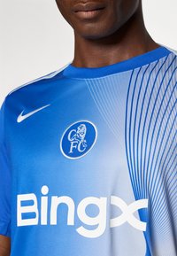Blue sports jersey made of soft fabric featuring a gradient design, white “Bingx” logo, and a circular blue logo with a lion emblem.