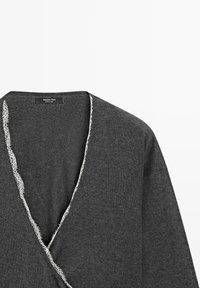 Cardigan en maille gris foncé style cache-cœur avec une délicate bordure en dentelle blanche le long de l'encolure en V et une étiquette Massimo Dutti à l'intérieur.