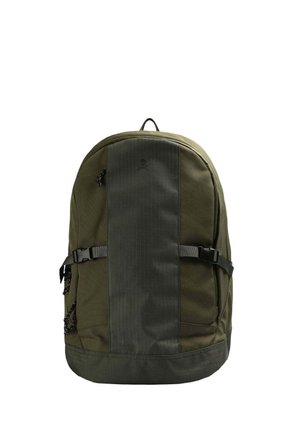 Mochila verde oliva con un panel frontal texturizado, correas ajustables, bolsillos laterales y un patrón de rayas horizontales. Cuenta con un asa en la parte superior.