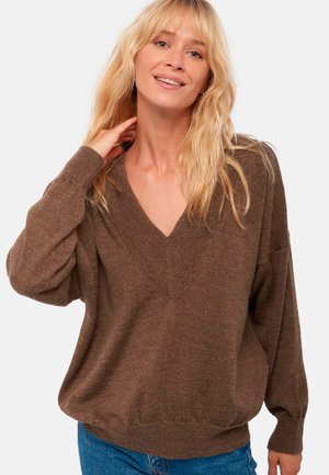 Pull marron en v avec des manches longues et amples, et un ourlet côtelé. Tissu doux et texturé conçu pour un ajustement décontracté.
