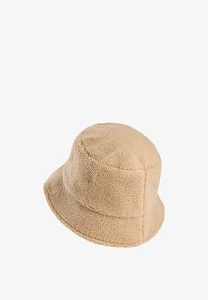 Beige bøttehat lavet af blød, tekstureret fleece. Har en rund krone og en bred, nedadgående skygge. Søm detaljer synlige.