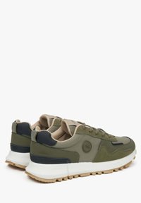 Sneakers w kolorze oliwkowym i beżowym wykonane są z siatkowych i zamszowych materiałów, mają okrągły czubek, teksturowaną gumową podeszwę oraz wyściełany kołnierz.